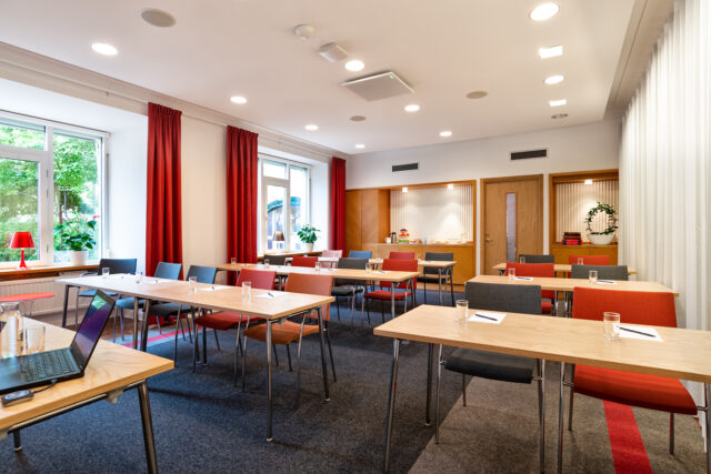 Konferenslokal möblerad i klassrumsstil.
